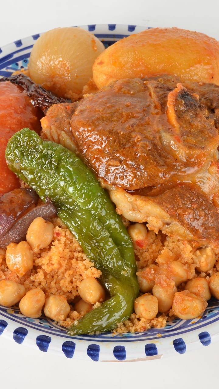 Une assiette de couscous tunisien avec agneau, pois chiches et légumes
